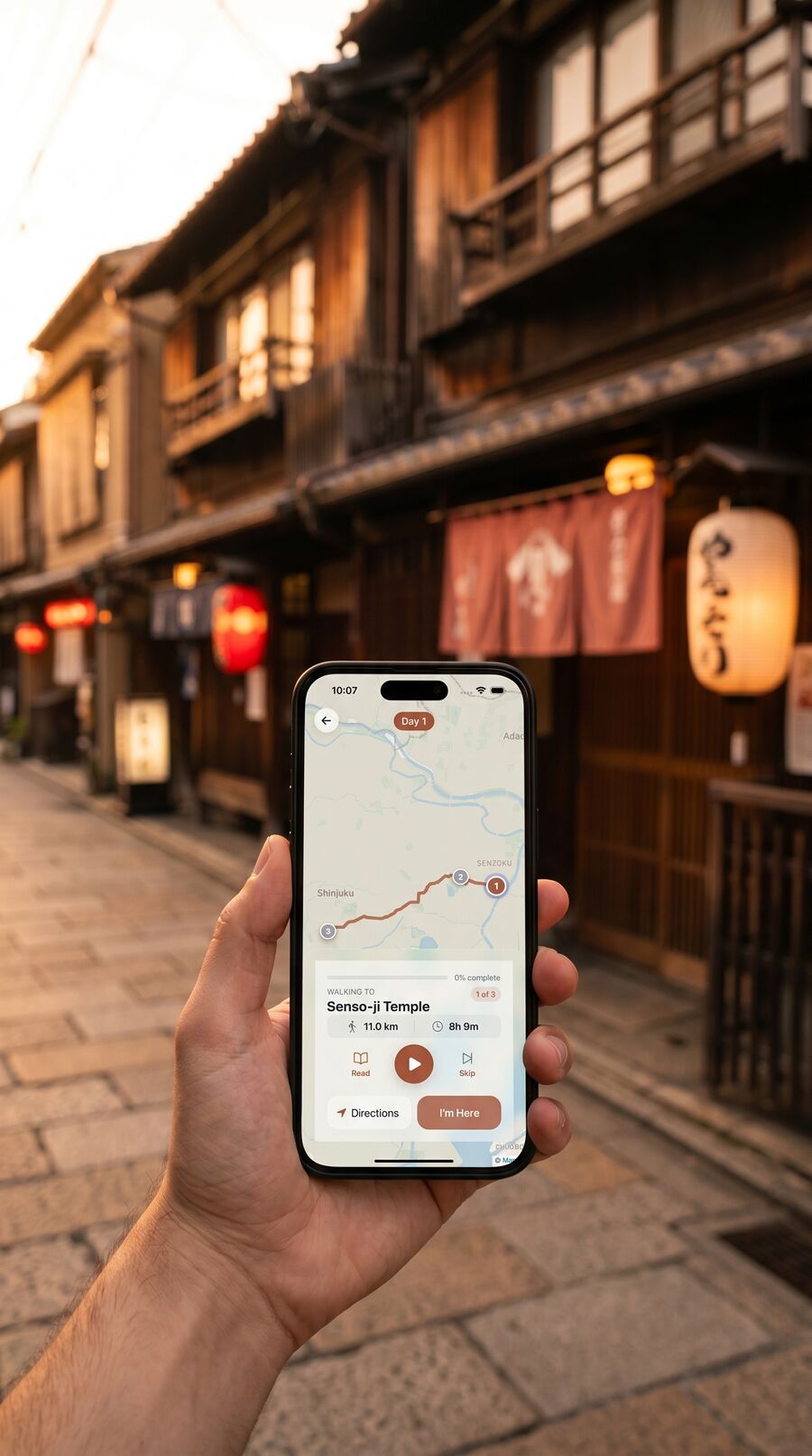 Hand holding iPhone showing Placeful walking to Senso-ji Temple in a Tokyo lantern-lit backstreet